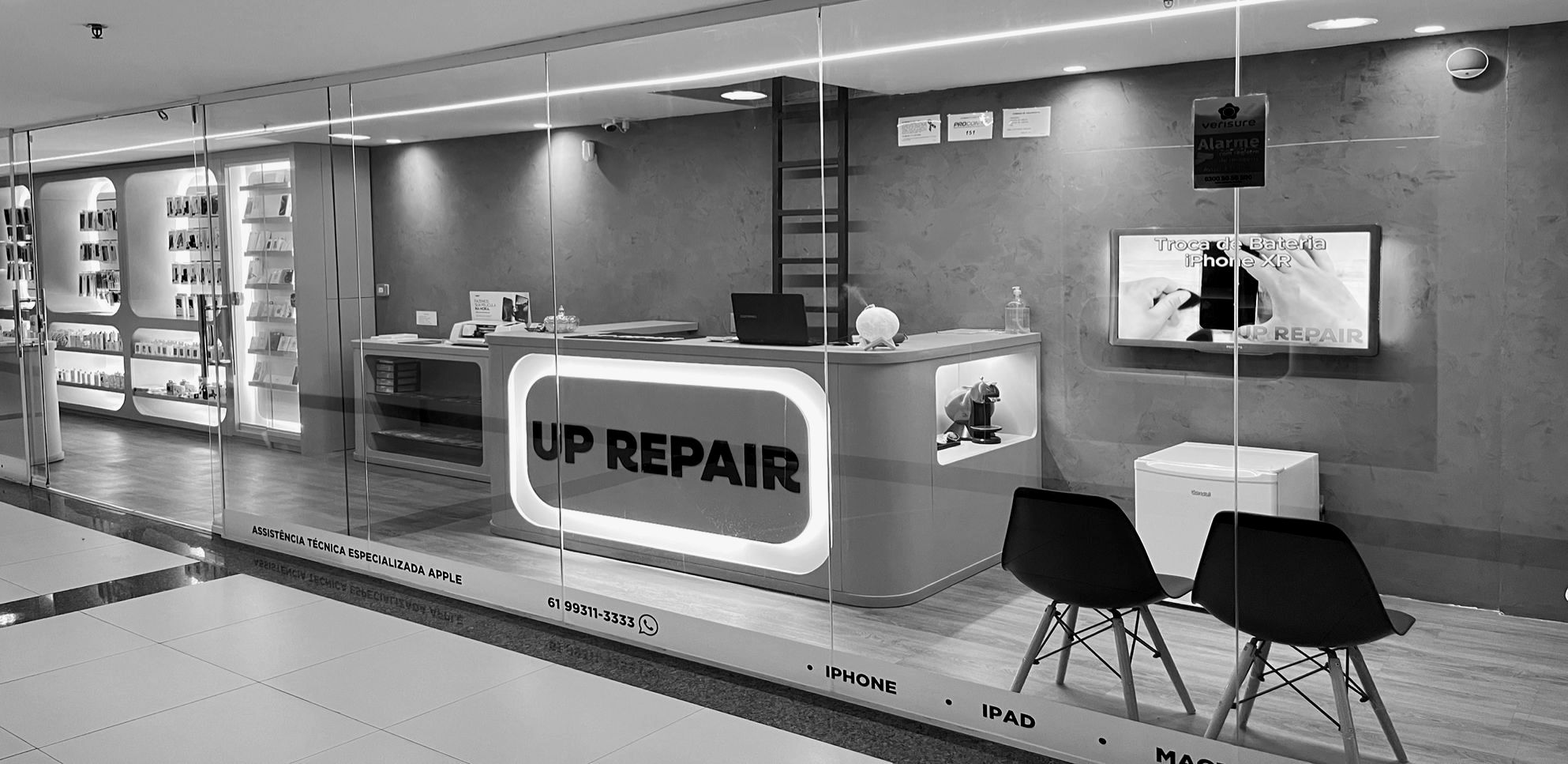 Interior da loja Uprepair no Lago Norte, com bancada técnica, vitrine de iPhones e área de espera